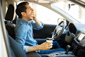 man yawning on road trip